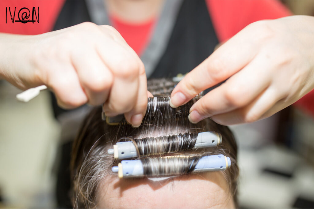 Hairstylist creating a tight curl perm for a lady
