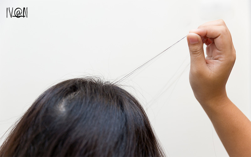 a woman pulling out damaged hair