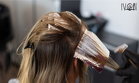 Hairdresser applying foil highlights to blonde hair